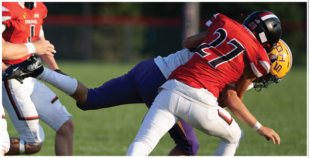 A football player is tackled to the ground. Description generated by AI