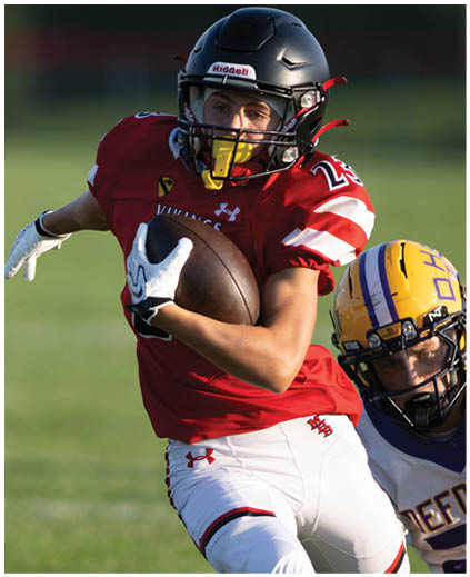 A football player in a red jersey with the number 11 on it. Description generated by AI