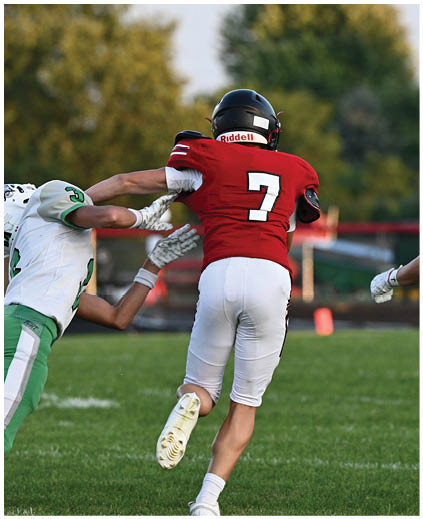 A football player in a red jersey is tackling another player. Description generated by AI