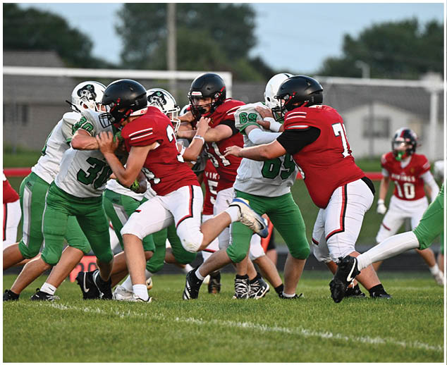 A group of football players in red and white uniforms are playing on a field. Description generated by AI