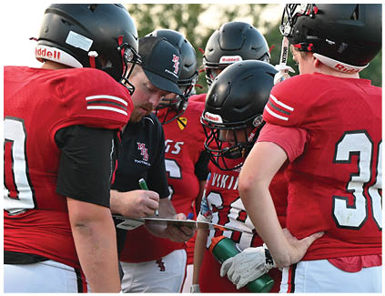 A group of football players wearing red jerseys. Description generated by AI