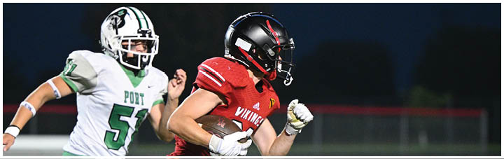A football player in a red jersey running on the field. Description generated by AI