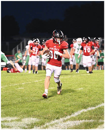A football player running on the field. Description generated by AI