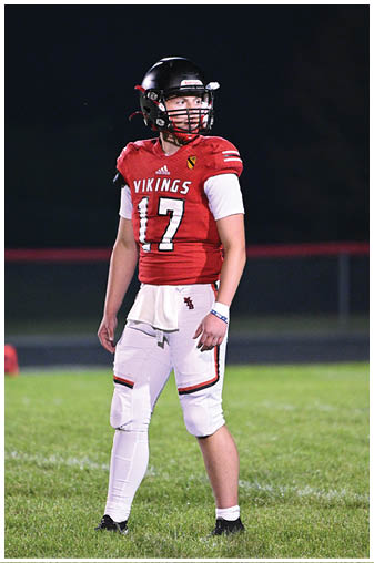 A football player wearing a red jersey with the number 17. Description generated by AI