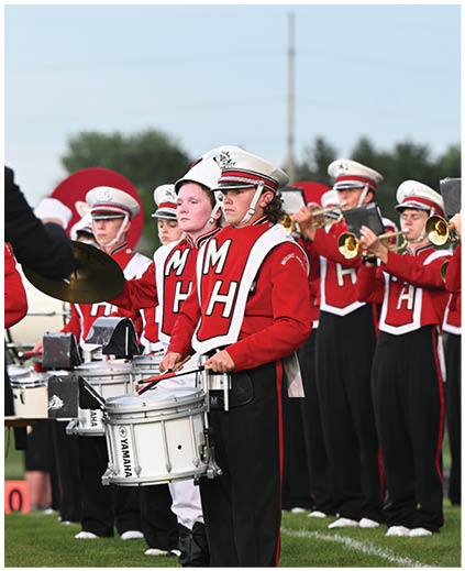 A group of people wearing red and white uniforms. Description generated by AI