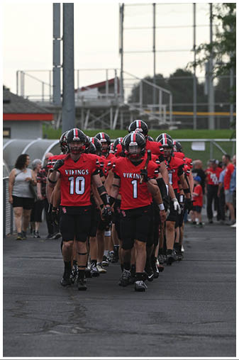 A group of people wearing red and black jerseys. Description generated by AI