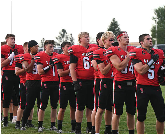 A group of football players wearing red and black uniforms. Description generated by AI