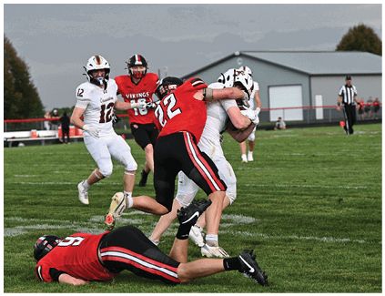 A football player is tackled to the ground. Description generated by AI