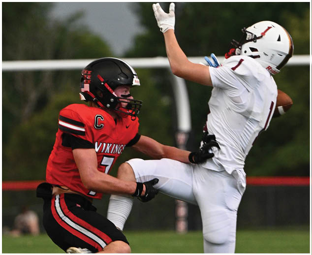 Two football players on a field. Description generated by AI
