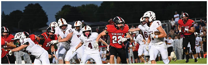 A group of football players running on a field. Description generated by AI