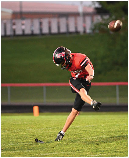 A football player in a red jersey catching a football. Description generated by AI