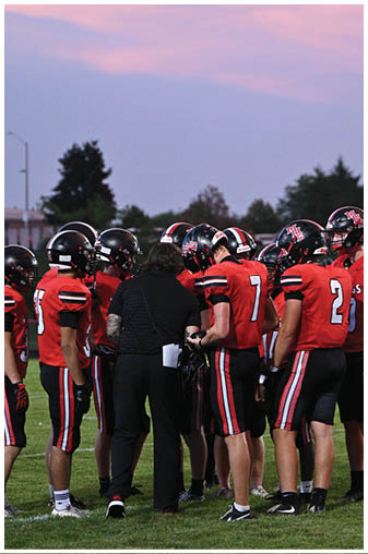 A group of football players in red and black uniforms. Description generated by AI