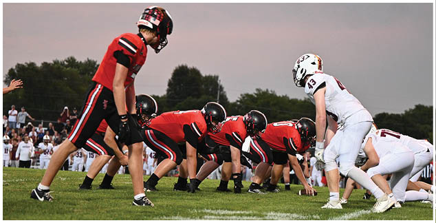 A football game is taking place with a group of men on the field. Description generated by AI