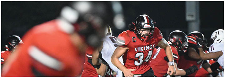 A football player in a red and black uniform with the number 31 on the back. Description generated by AI