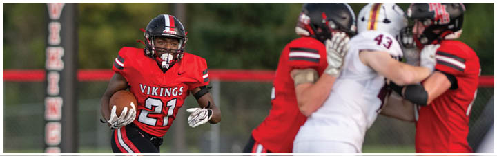 A football player in a red jersey running on the field. Description generated by AI