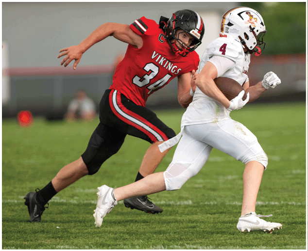 A football player in a red jersey running on the field. Description generated by AI