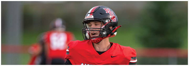 A football player in a red and black jersey with the number 3 on it. Description generated by AI