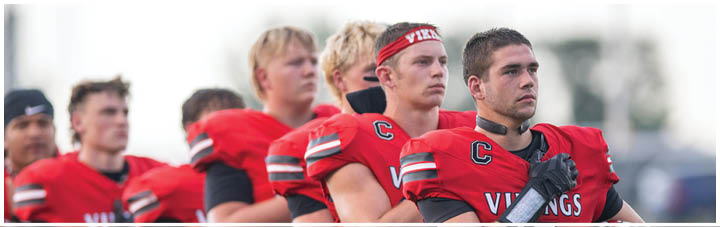 A group of football players wearing red and black uniforms. Description generated by AI