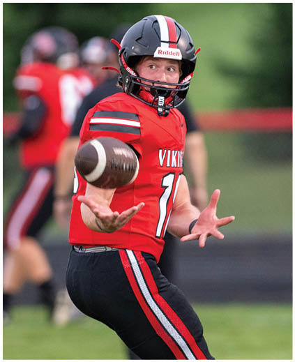 A man wearing a red and black jersey with the number 11 on it. Description generated by AI