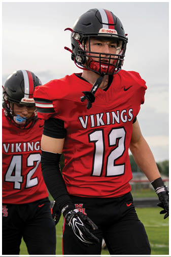 A man wearing a red jersey with the number 12 on it. Description generated by AI