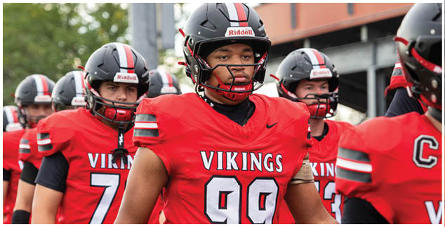 A group of football players wearing red and black uniforms. Description generated by AI