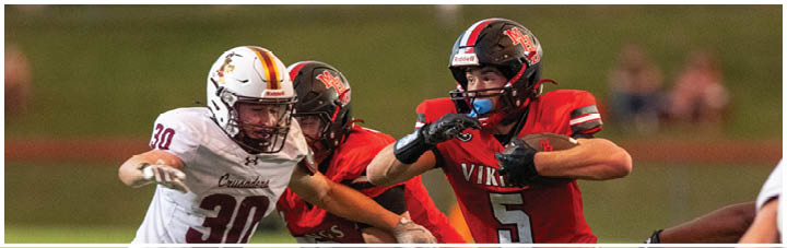 A football player in a red jersey is tackling another player. Description generated by AI