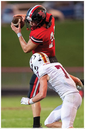 A football player in a red jersey catches a ball. Description generated by AI