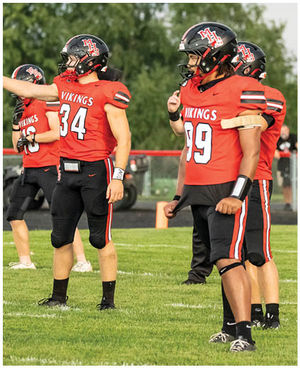A group of football players wearing red jerseys. Description generated by AI