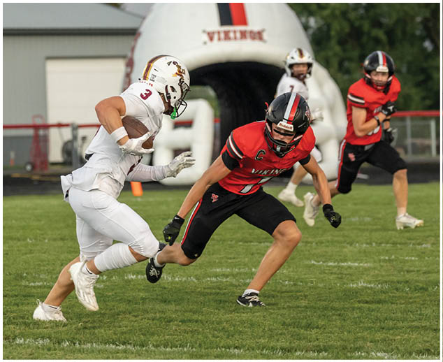 A football player running with a football. Description generated by AI