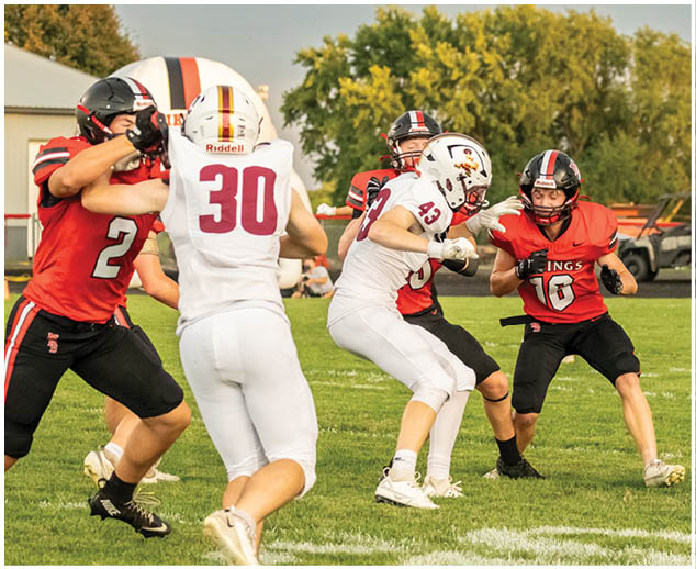 A football game is being played with players wearing red and white uniforms. Description generated by AI