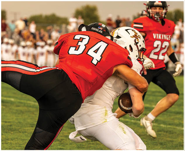 A football player is tackled to the ground. Description generated by AI