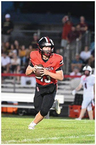 A football player in a red jersey catching a ball. Description generated by AI
