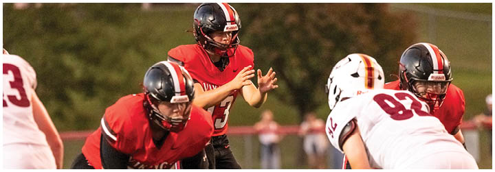 Two football players on a field. Description generated by AI