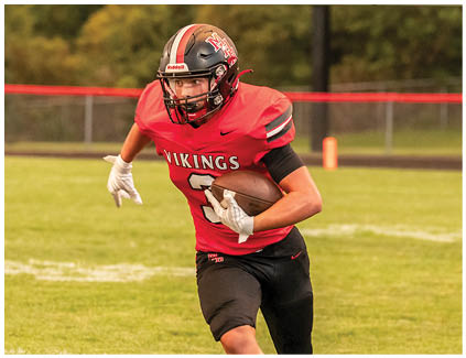 A football player running on the field. Description generated by AI