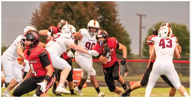 A football game is in progress with players on the field. Description generated by AI