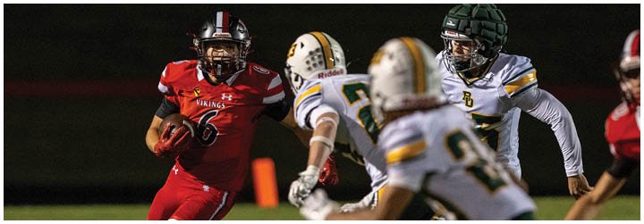 A football player in a red jersey running with the ball. Description generated by AI