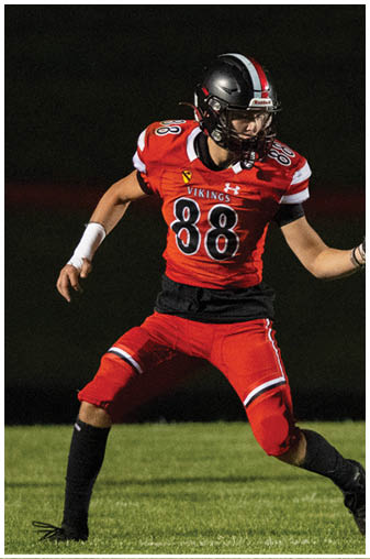 A football player in a red jersey is tackling another player. Description generated by AI