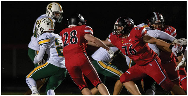 A football player in a red jersey is running with the ball. Description generated by AI