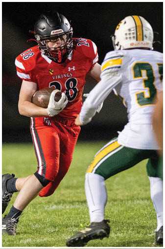 A football player wearing a red jersey with the number 38 on it. Description generated by AI