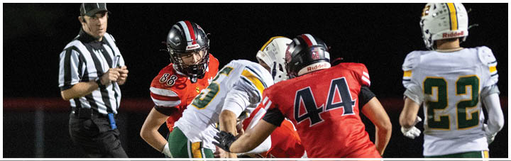 A football player in a red jersey is tackled to the ground. Description generated by AI