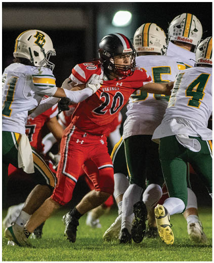 A football player in a red jersey is running with the ball. Description generated by AI