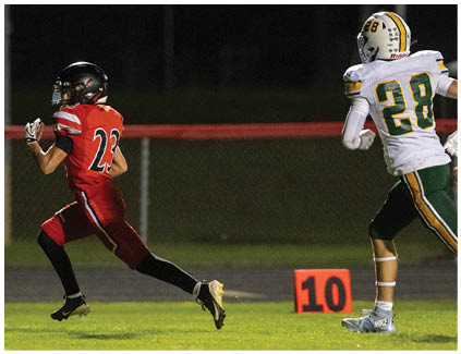 A football player in a red jersey running with the ball. Description generated by AI