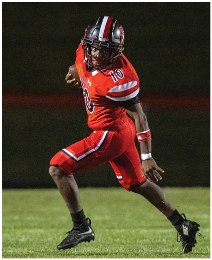 A football player is running with the ball. Description generated by AI