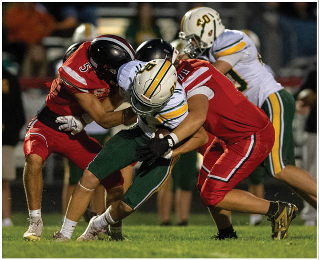 A football player in a red jersey is tackling another player. Description generated by AI