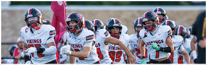 A group of football players wearing black and red uniforms. Description generated by AI