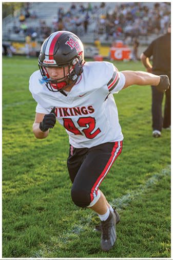 A football player running on the field. Description generated by AI