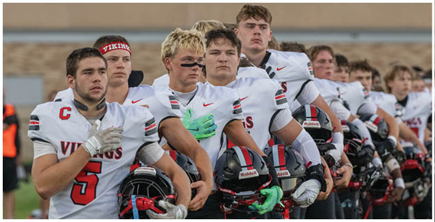A group of football players wearing black and white uniforms. Description generated by AI