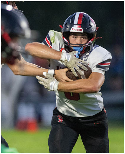 A football player wearing a black jersey with the number 13 on it. Description generated by AI