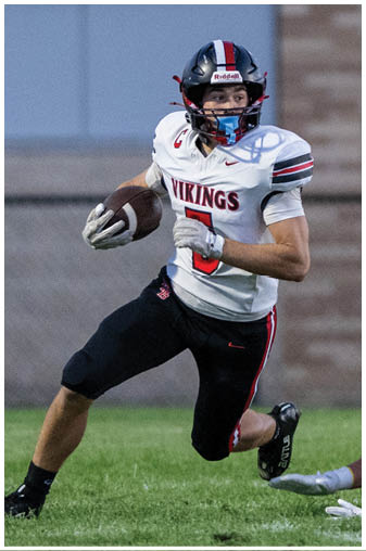 A football player in a white jersey with the number 3 on it running with the ball. Description generated by AI