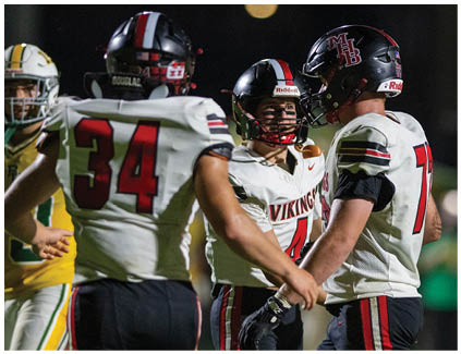 Two football players wearing black and white uniforms. Description generated by AI